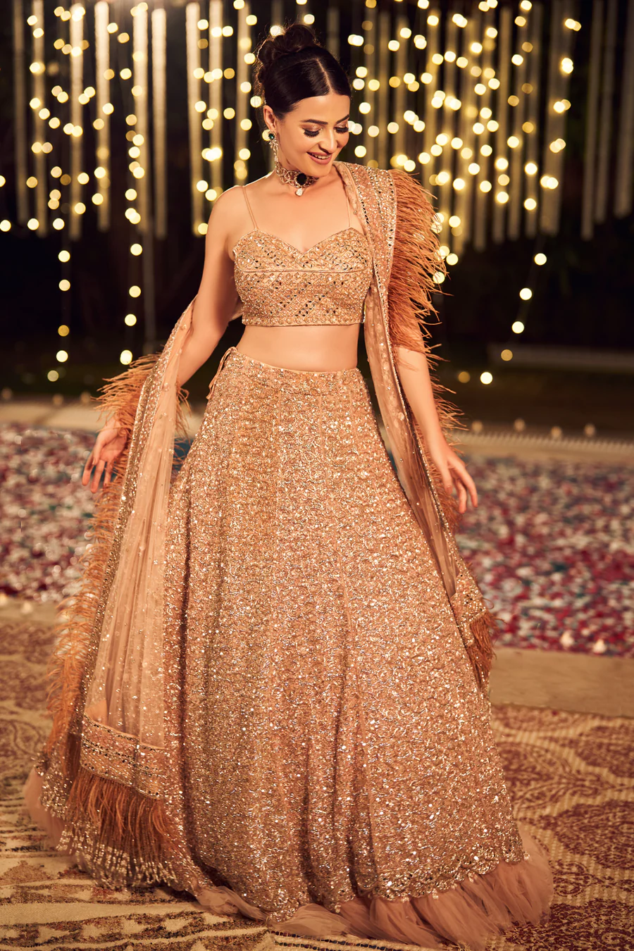 Brown leather key ring with brass metal loops and rivets on wood table.